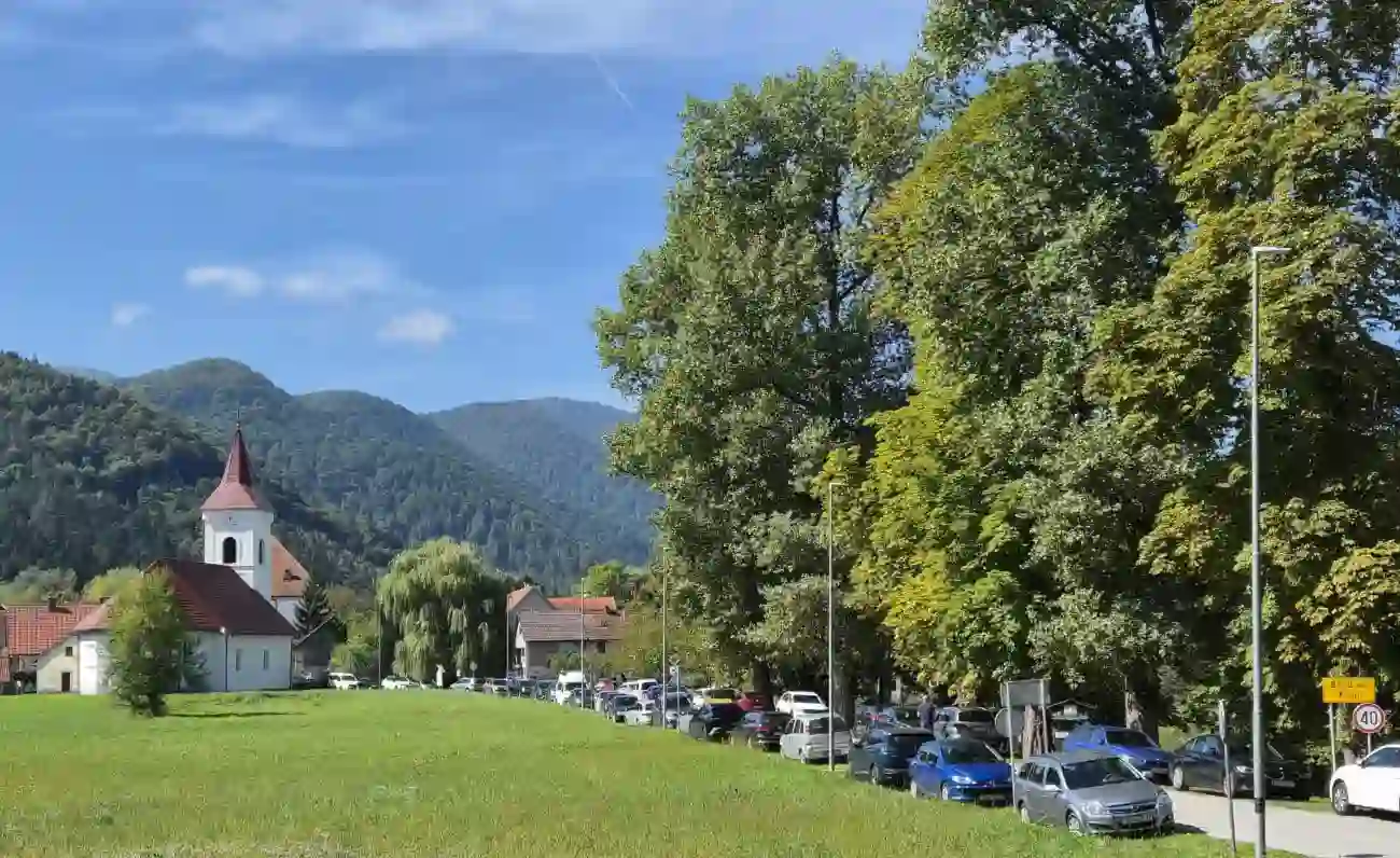 Brod na Kupi, crkva, priroda, parkirani auti mnogobrojnih posjetitelja.